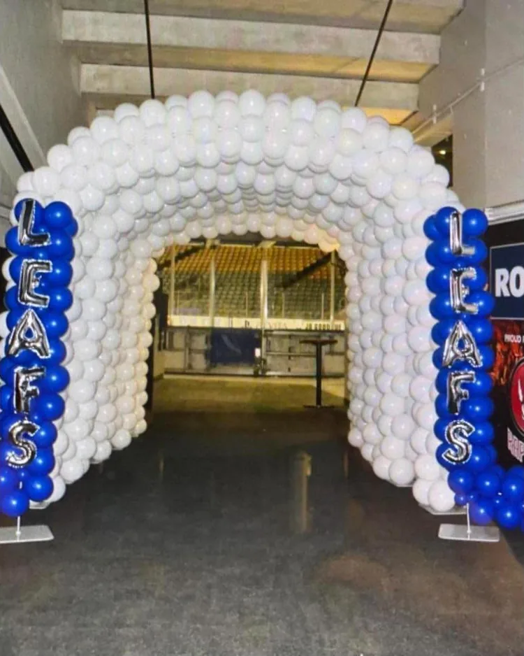 White walk-through balloon tunnel with blue balloon columns spelling LEAFS in silver foil letters
